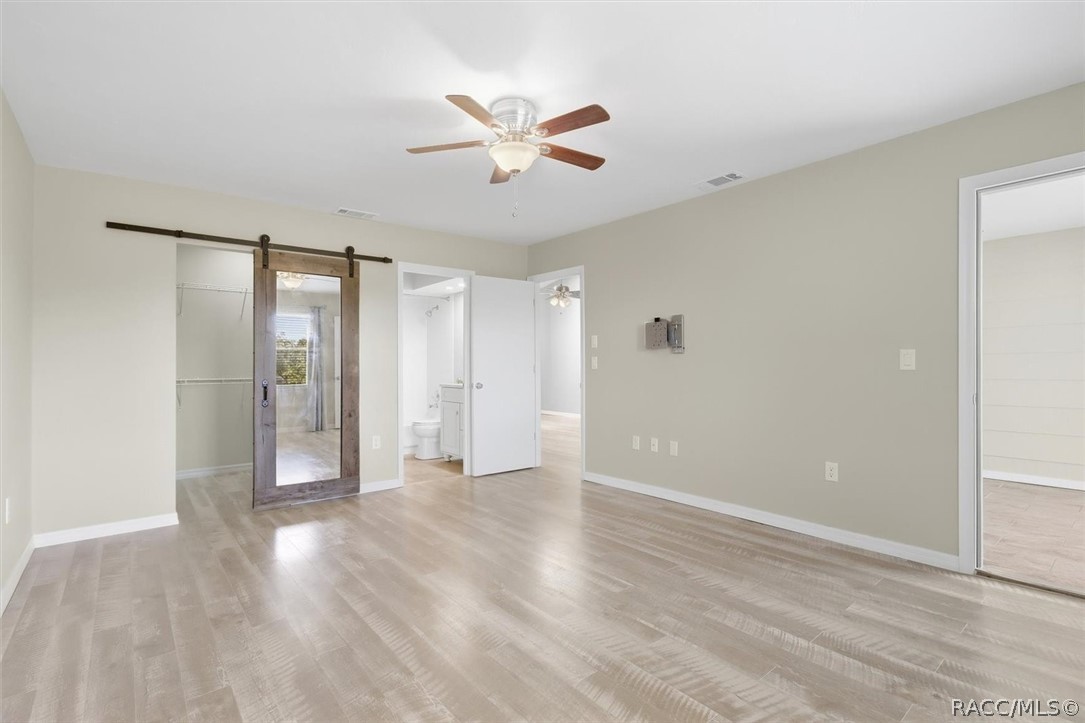 Primary bedroom with ensuite and custom barn door to walk-in closet