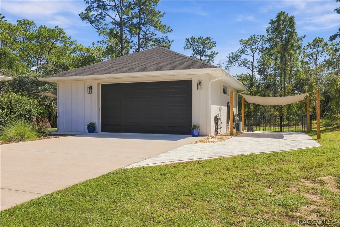 DETACHED 30x30 GARAGE + PAVER PARKING AREA
Detached garage w/ coordinating board-and-batten-style exterior, contrasting dark garage door & exterior lighting. An extended paver area alongside the garage provides additional outdoor space, while the shade-sail setup & nearby fencing add extra function to the backyard.