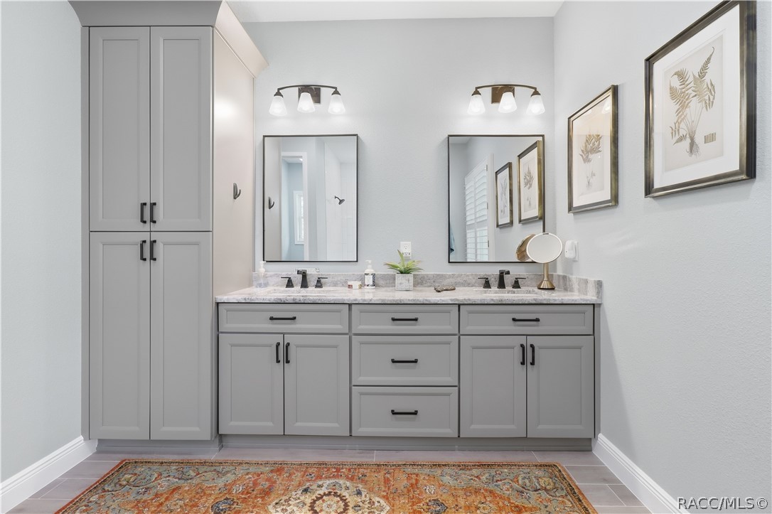 PRIMARY BATH DUAL VANITY  Beautifully finished primary bath features an expansive dual-sink vanity w/
abundant cabinetry, granite countertops, individual framed mirrors & stylish black fixtures. A full-height
linen/storage cabinet adds exceptional everyday storage.