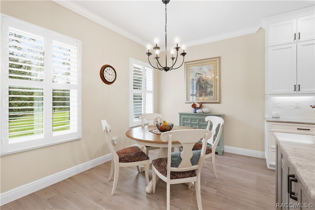CASUAL DINING  Light-filled dining nook features plantation shutters, crown molding, chandelier lighting & direct connection to the kitchen for effortless everyday dining.