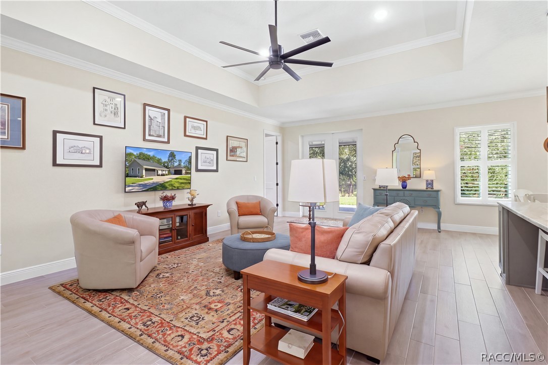 LIVING AREA  Generous great room combines high ceilings, crown molding, recessed lighting, neutral finishes & plantation shutters for a bright, refined feel.