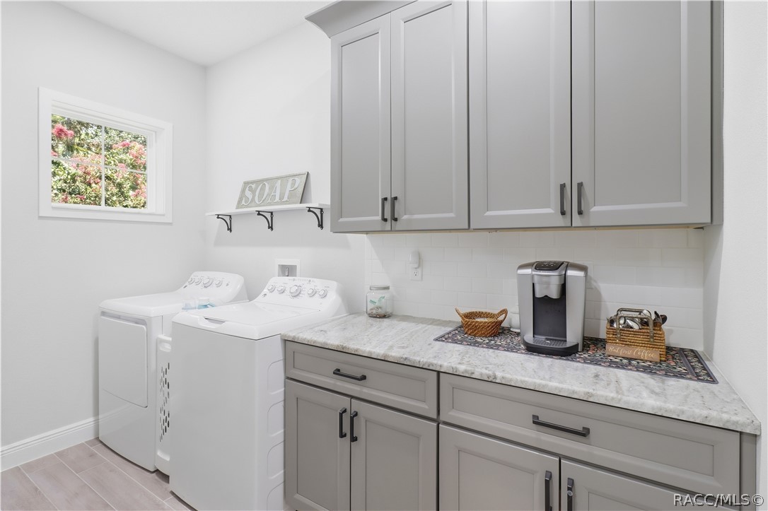 INDOOR LAUNDRY ROOM  Spacious indoor laundry offers much more than washer & dryer space! Extensive upper & lower cabinetry, generous countertop workspace, subway-tile backsplash, black hardware & a window for natural light provide outstanding organization & functionality.