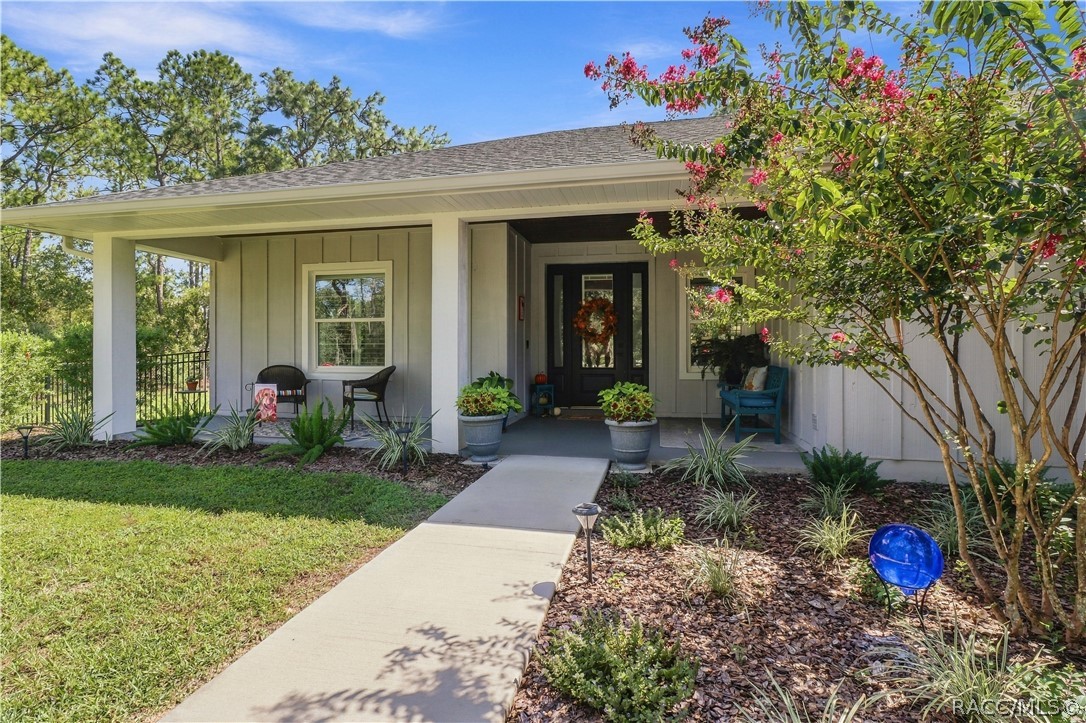 INVITING FRONT ENTRY  Covered front porch framed by landscaped beds & flowering crepe myrtle, w/ substantial columns, recessed entry & a welcoming walkway.
