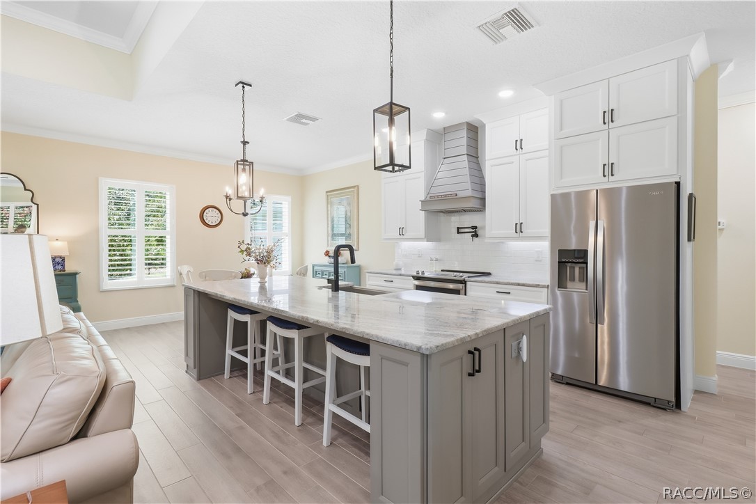 OVERSIZED KITCHEN ISLAND  Generous contrasting island provides substantial prep space & seating for three accented by granite counters, statement pendant lights, deep sink & modern black fixtures.  Lots of Storage for all your needs!
