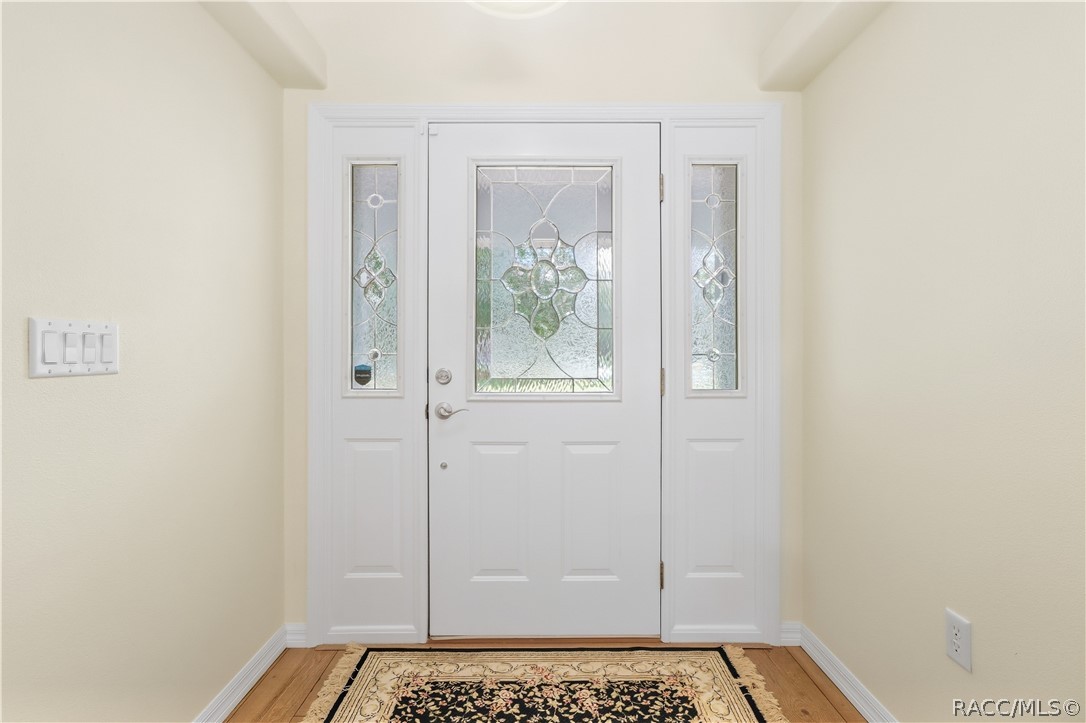 Foyer  Bright entry featuring decorative glass front door with matching sidelights and laminate flooring.