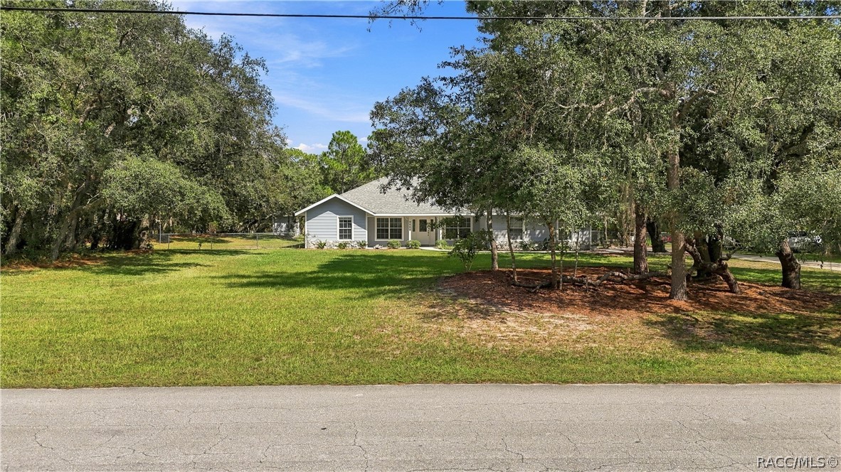 SPACE & PRIVACY FROM THE STREET  Wide front yard with mature trees creating a naturally buffered setting.