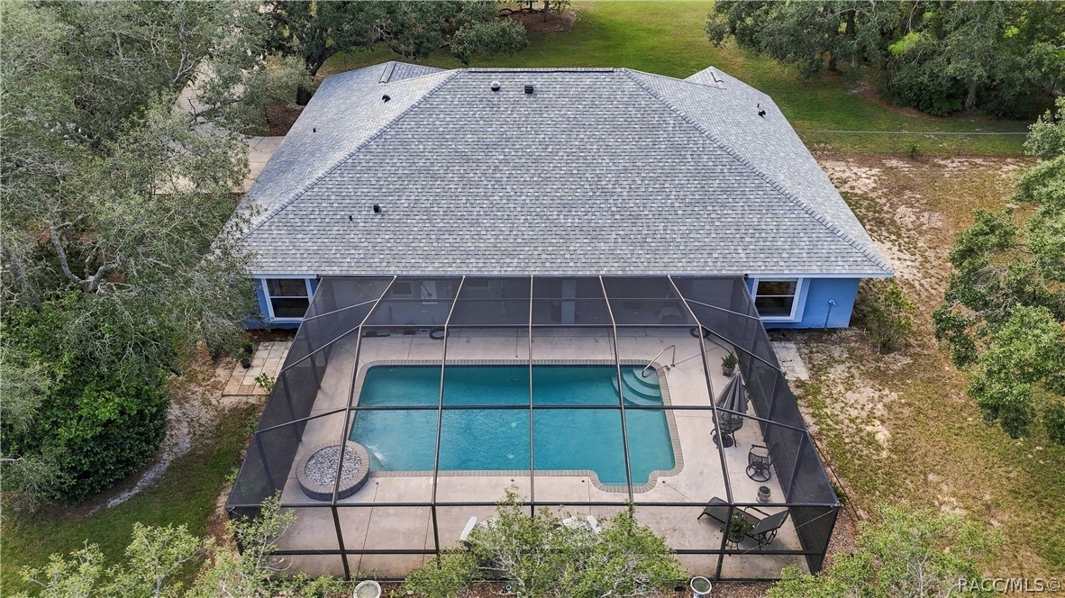POOL LIVING FROM ABOVE  Aerial view showcases the impressive size of the screened pool enclosure, expansive pool deck & covered outdoor living area.