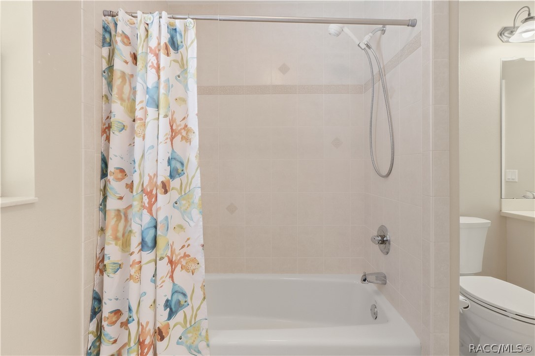 Guest Bathroom  Closer view of the tiled tub/shower combination with handheld showerhead.