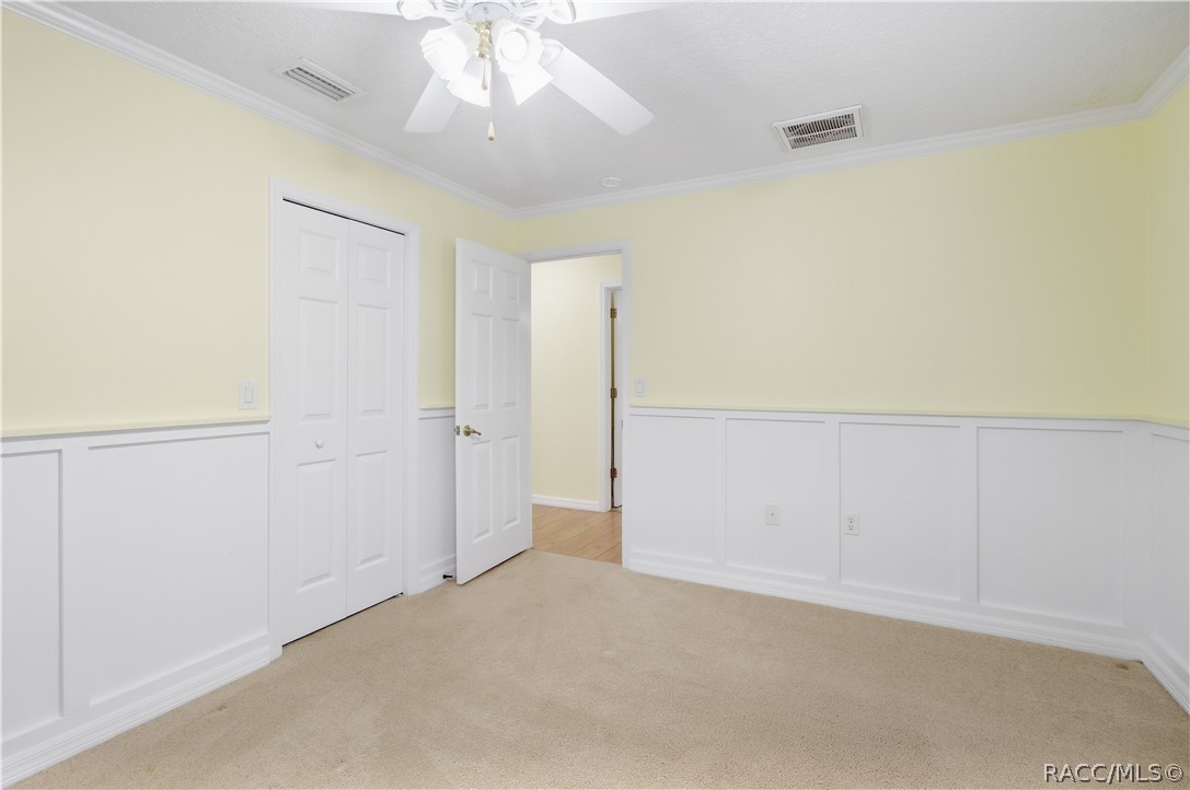 Additional Guest Bedroom  Spacious room with crown molding, ceiling fan, closet and decorative wall molding/wainscoting.