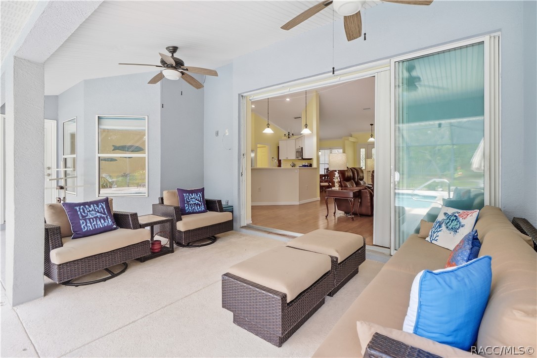 Covered Lanai  Alternate view showing the spacious seating area, dual ceiling fans and pocket sliding-door connection to the interior.
