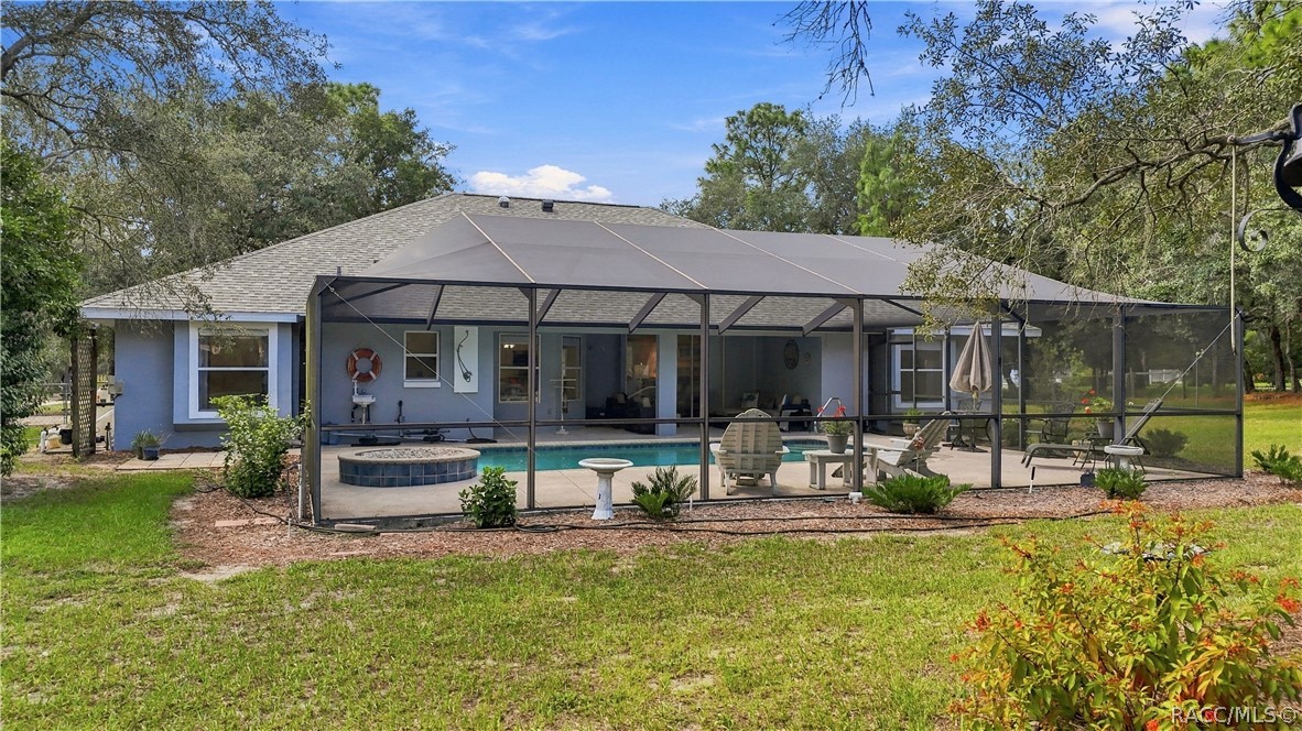 A BACKYARD BUILT FOR FLORIDA LIVING  Full view of the oversized screened pool enclosure extending across the rear of the home.
