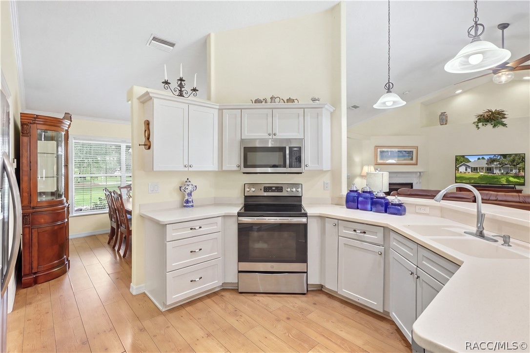 Kitchen / Open Floor Plan  Additional kitchen view showcasing the cabinetry, stainless-steel appliances, breakfast bar & open connection to the living area.