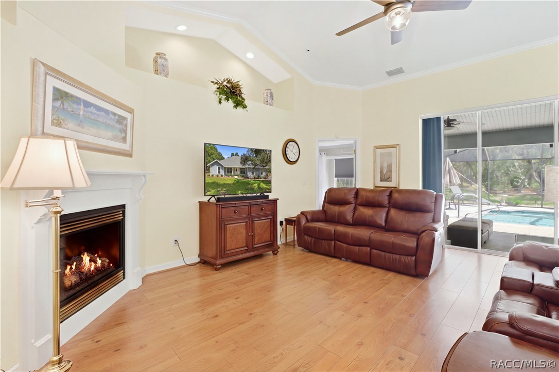 Living Room / Pool View  Open living space with gas fireplace and large sliding glass doors providing a direct view into the screened pool area.