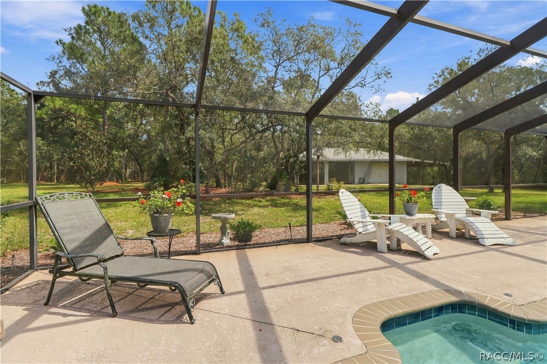 Pool & Backyard View  Screen-enclosed pool and spa overlooking the spacious backyard with mature trees and plenty of outdoor space.