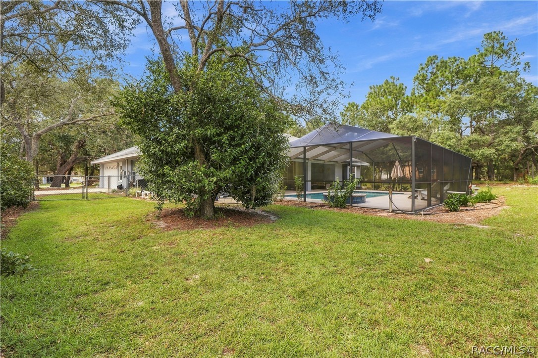 ROOM TO SPREAD OUT  Spacious backyard surrounded by mature trees with the screened pool area just steps from the home.