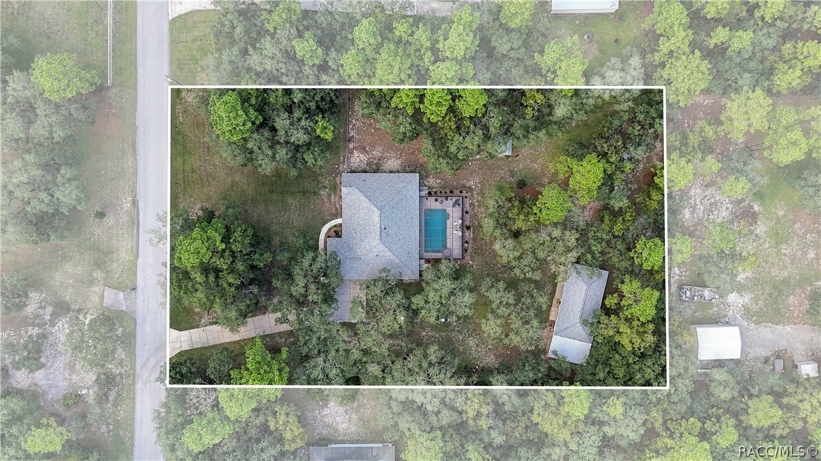Aerial View  Overhead view showcasing the spacious homesite, residence, screened pool area, detached garage/outbuilding, mature trees & surrounding property.