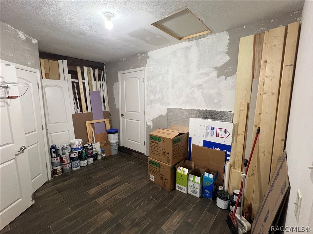 Interior room with laundry closet, half bath and door to front bedroom and supplies and paint for projects