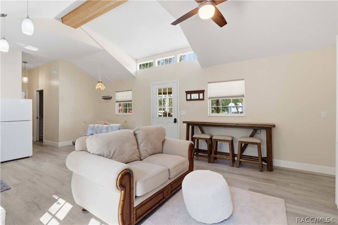Open Floor Plan  Natural light fills this cheerful living space featuring VAULTED CEILINGS, decorative wood beam, clerestory windows & a convenient breakfast bar area. An inviting place to relax or gather!