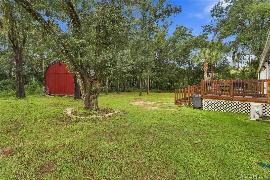 Spacious Backyard  Enjoy the natural setting w/mature shade trees, green lawn, wooden rear deck & detached storage building. Plenty of outdoor space to enjoy!