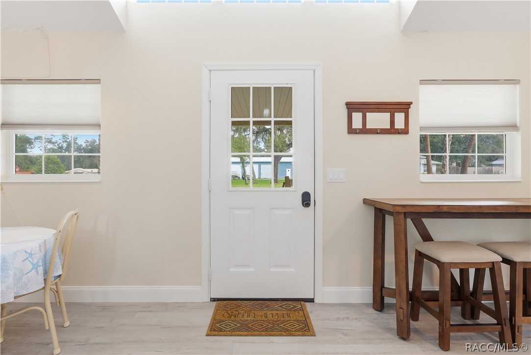 Front Entry  Bright & welcoming entrance featuring a glass-paneled front door, natural light, attractive flooring & space for additional seating.