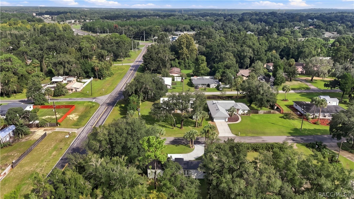 Aerial Neighborhood View  Elevated view highlighting the home's corner setting, surrounding residential neighborhood, mature trees & nearby roadways.