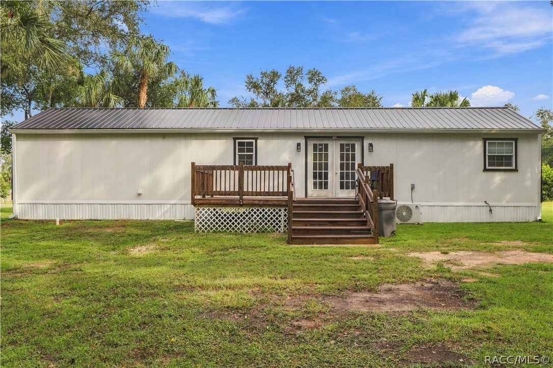 Rear Exterior  Attractive rear elevation featuring the METAL ROOF, French doors, wooden deck w/steps & a MINI-SPLIT HEATING & COOLING SYSTEM.