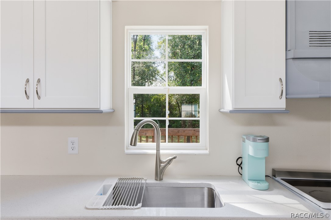 Kitchen Sink & Window  Stainless-steel sink w/pull-down faucet, solid surface countertop & window overlooking the greenery outside.