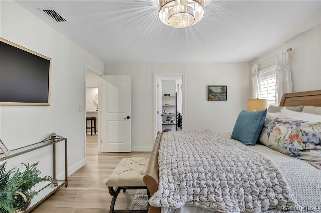 Primary bedroom with wood bed frame and dresser.