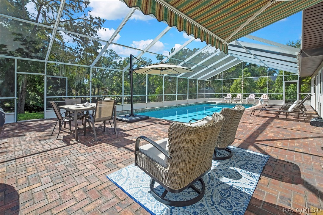 Screen-enclosed pool and brick paver deck with lounge seating Screen-enclosed pool and brick paver deck with lounge seating