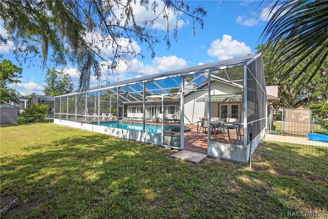 Back of the home and pool enclosure from the yard.