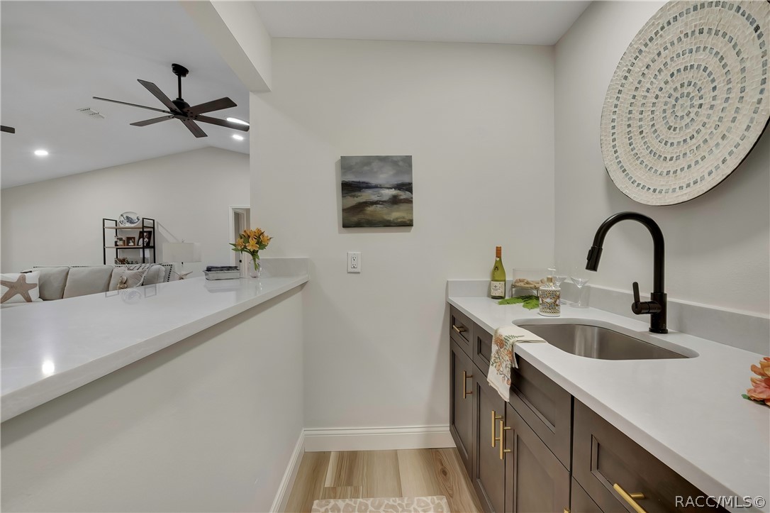 Wet bar with sink and cabinet storage off the living area.