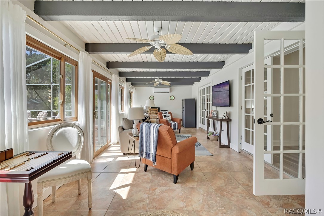 Second living area with beamed ceilings and French doors.