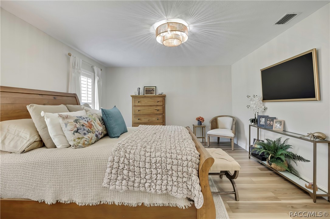 Primary bedroom with sitting chairs and dresser.