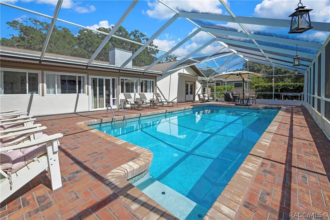 Pool with lounge chairs on the brick deck.