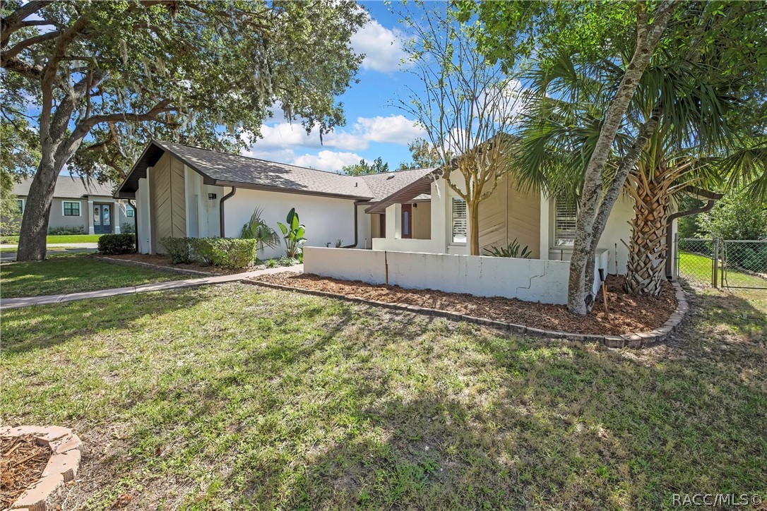 Front of the home with lawn and mature trees Front of the home with lawn and mature trees