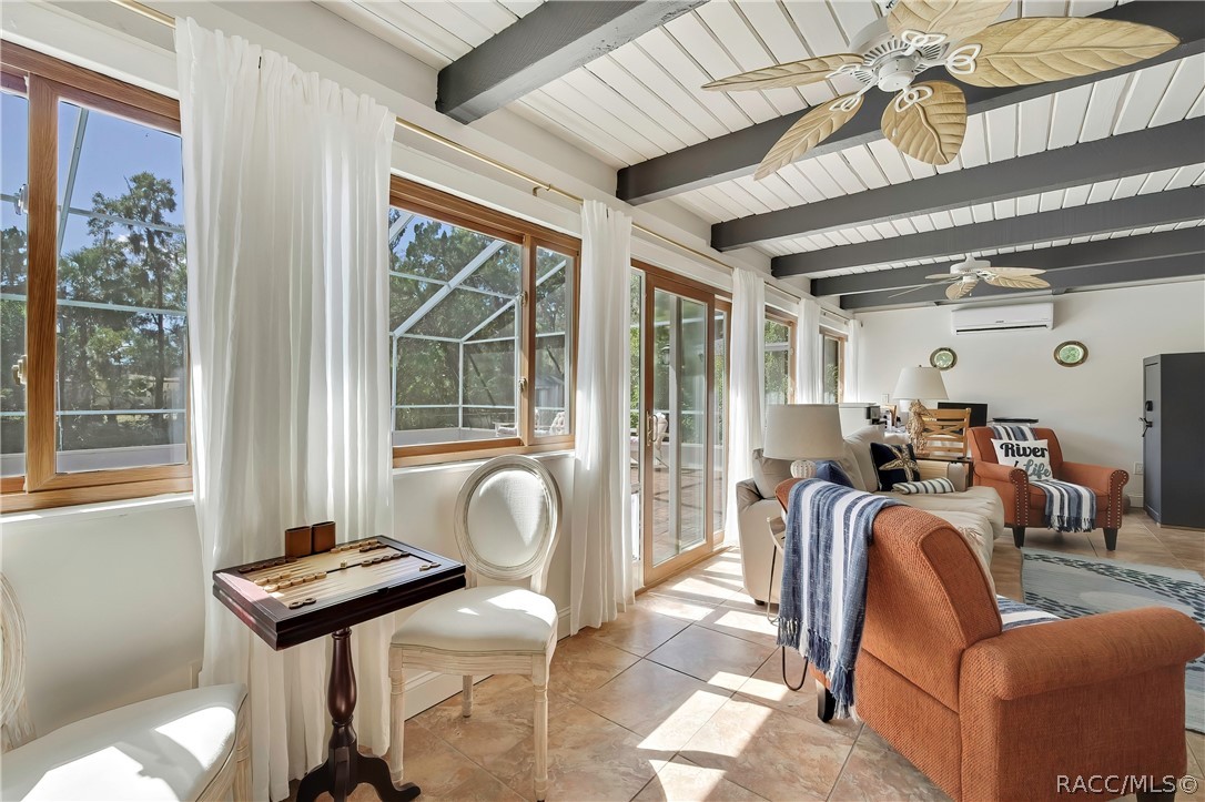 Second living area with beamed ceilings and French doors.