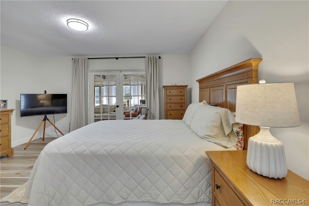 Bedroom with bedside lamp and sliding doors beyond