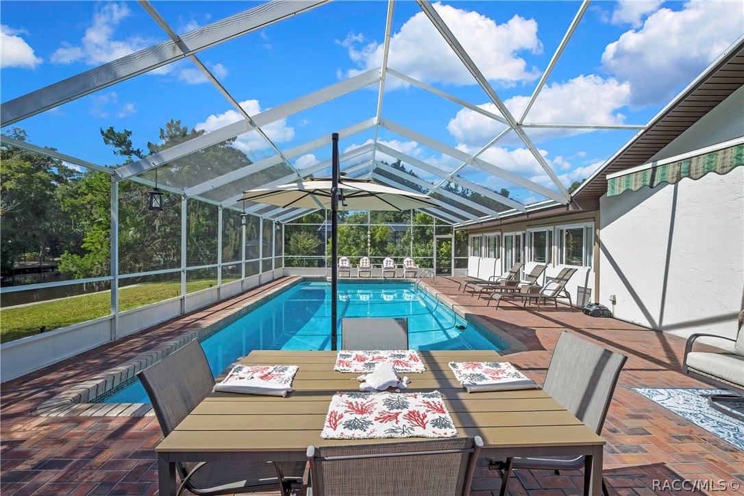 Screen-enclosed pool with patio dining set.