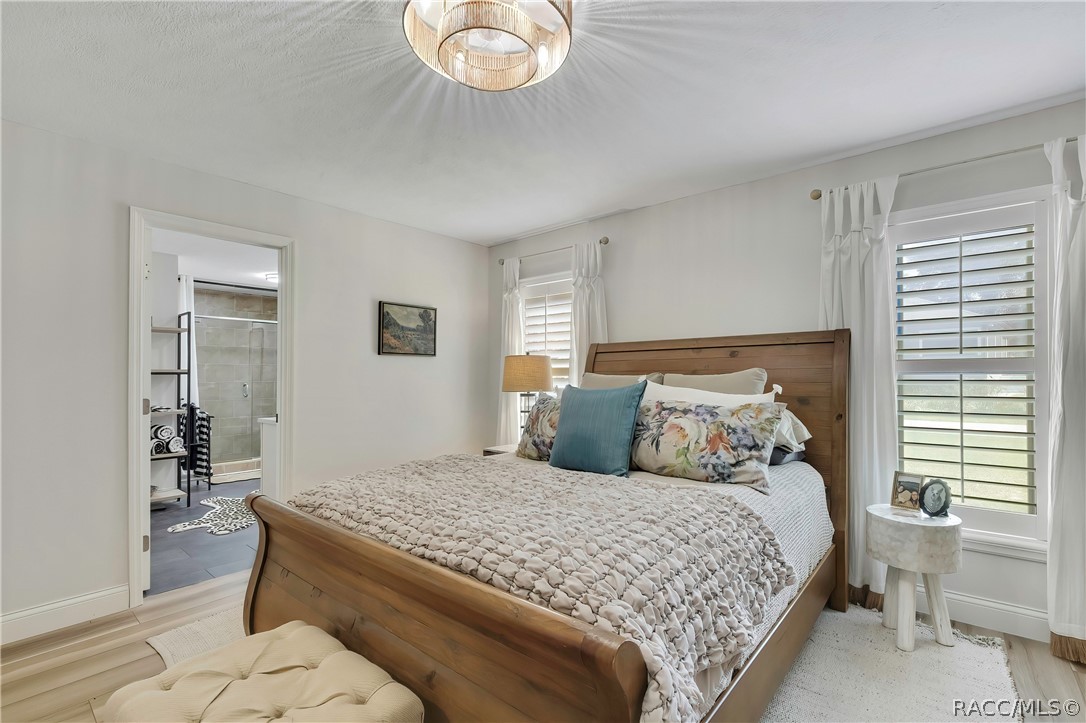 Primary bedroom with wood bed frame and dresser.