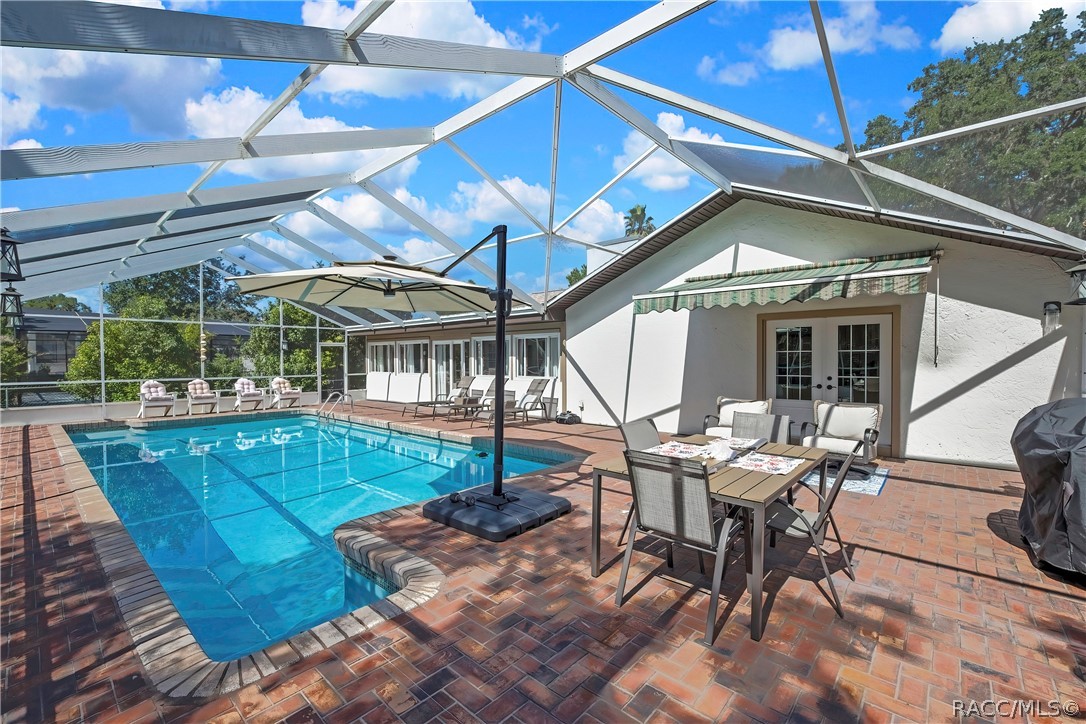 Pool deck with outdoor dining beside the home.
