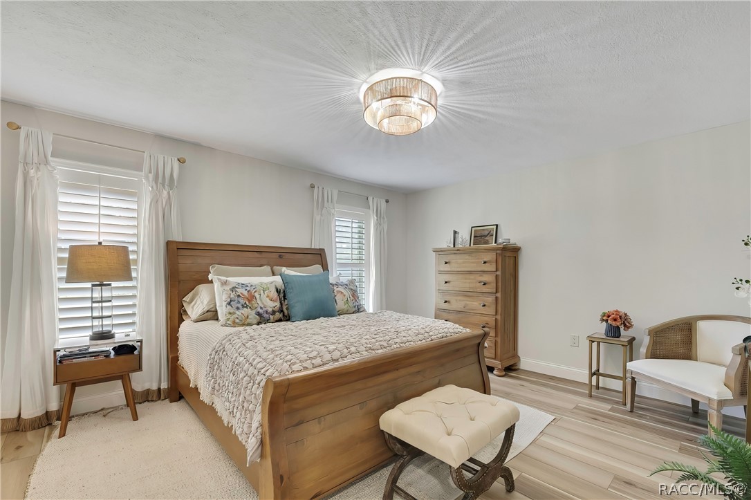 Primary bedroom with wood bed frame and dresser.