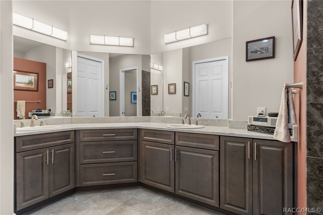 You'll appreciate the amount of storage in the primary bath, complete with a linen closet, visible in the mirror's reflection.