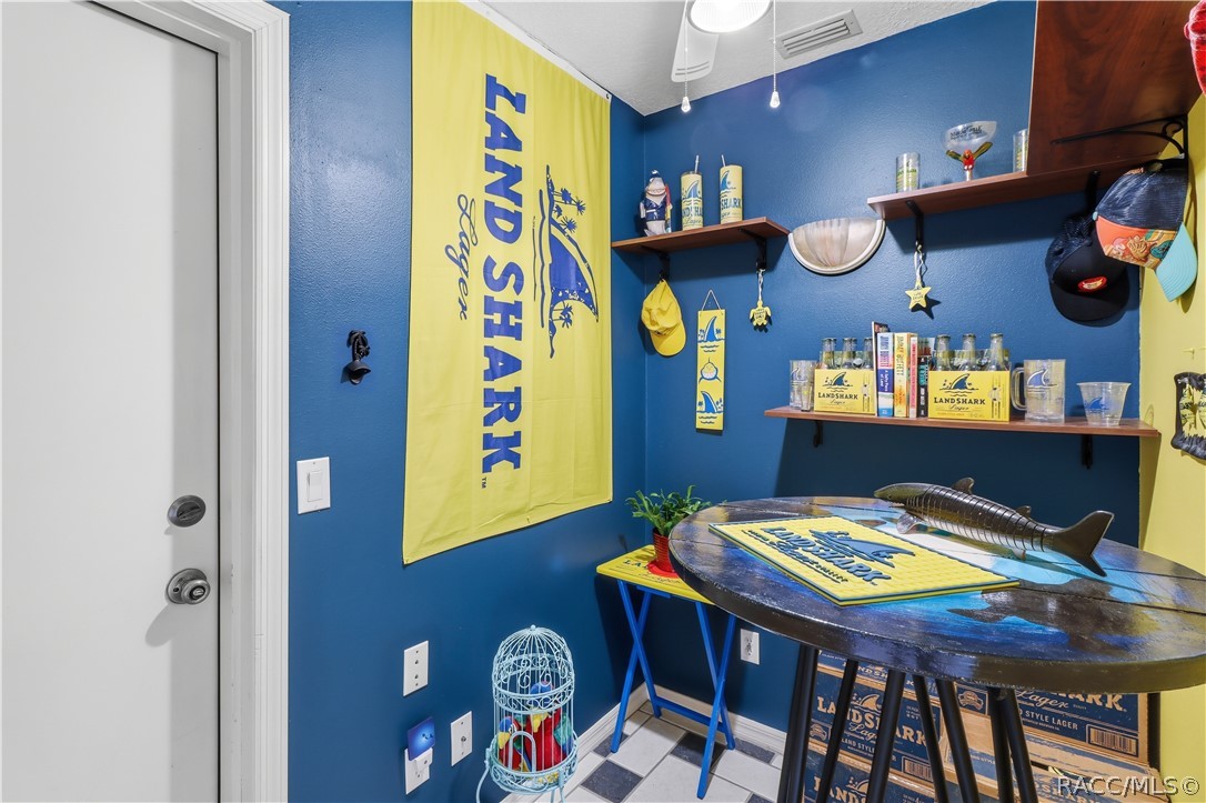 Additional view of the bonus room showcasing shelving, overhead lighting, and entry door from the garage.