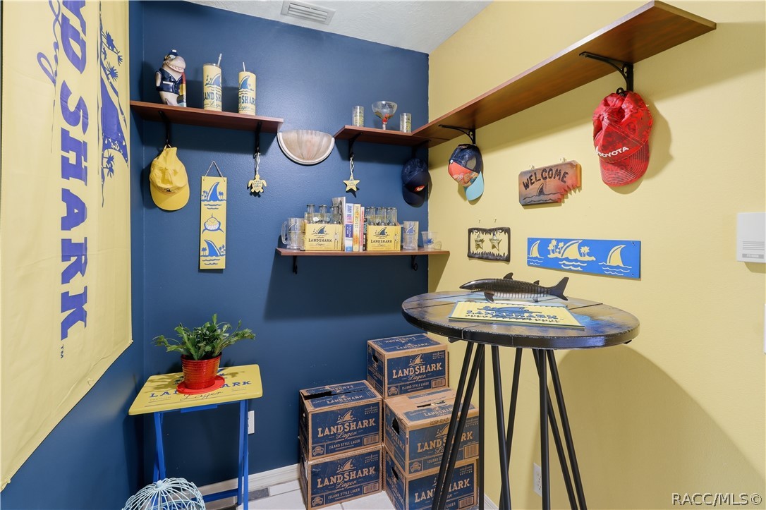 Versatile bonus room featuring built-in wall shelving and space for a small table, hobby area, or personal retreat.