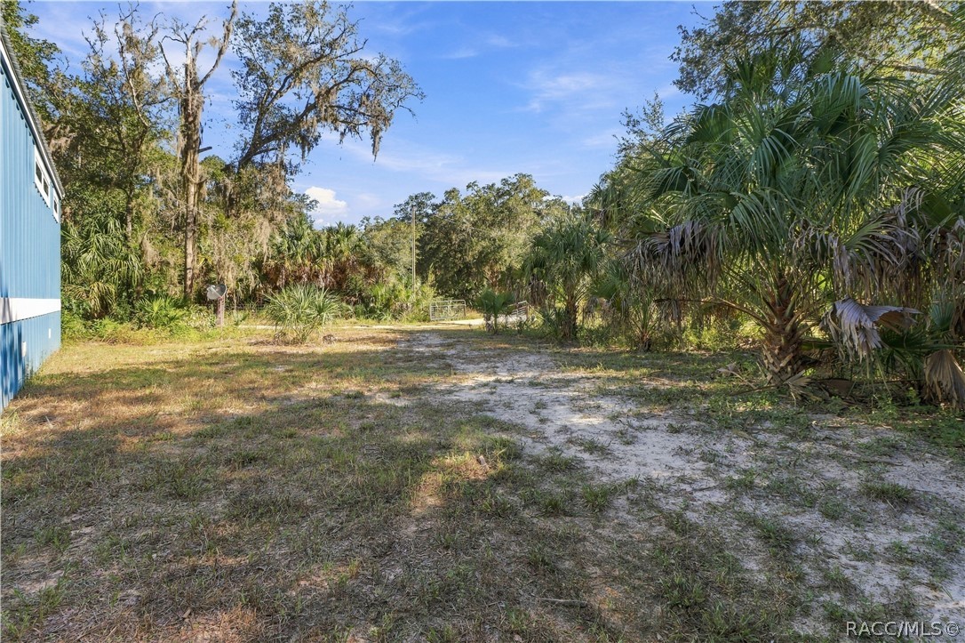 BRING YOUR TOYS & ENJOY THE SPACE! The 1.42-ACRE FULLY FENCED PROPERTY offers open areas, mature trees, Florida palms & a gated entrance.