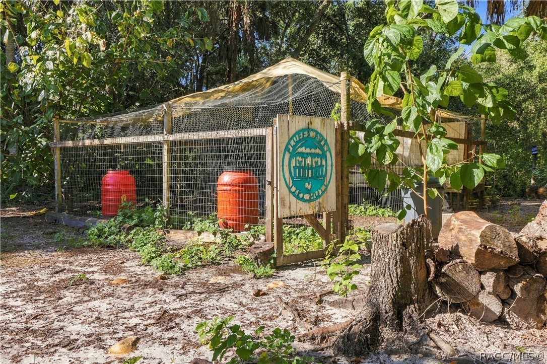 A LITTLE COUNTRY CHARM! This fenced outdoor enclosure offers a dedicated space surrounded by mature trees & natural Florida greenery.