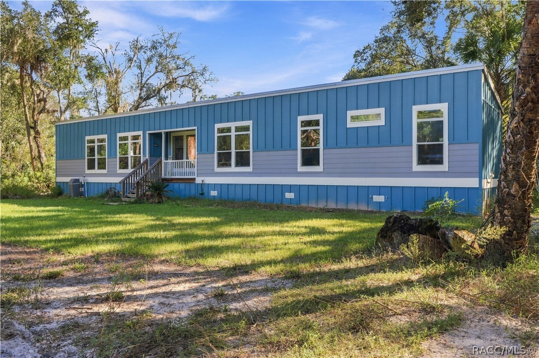 COUNTRY CHARM MEETS MODERN STYLE! Built in 2024, this attractive modular home features a cheerful blue exterior, contrasting white trim & METAL ROOF, all surrounded by Florida's natural beauty.