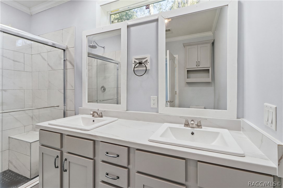 A BEAUTIFULLY FINISHED PRIMARY BATH! Enjoy a DOUBLE-SINK VANITY w/GRAY CABINETRY, marble-look countertops, framed mirrors & a spacious WALK-IN SHOWER.