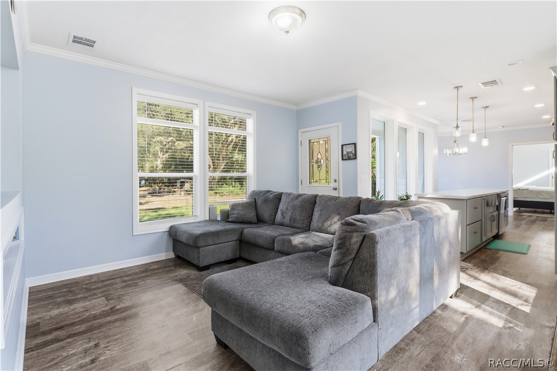 RELAX & MAKE YOURSELF COMFORTABLE! The spacious LIVING ROOM features attractive flooring, abundant natural light & an open connection to the kitchen.