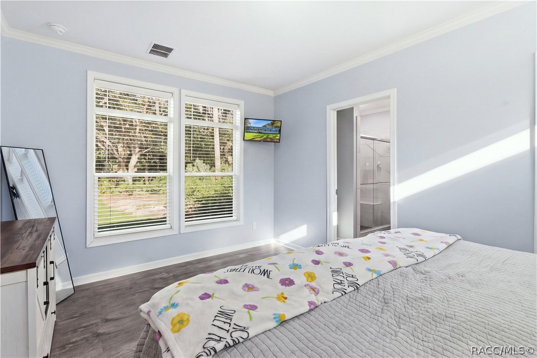 BRIGHT & RELAXING PRIMARY SUITE! Large windows overlook the natural surroundings, while the adjoining PRIVATE BATH offers a convenient WALK-IN SHOWER.